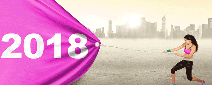 athletic lady pulling a pink banner dated 2018 across a city skyline