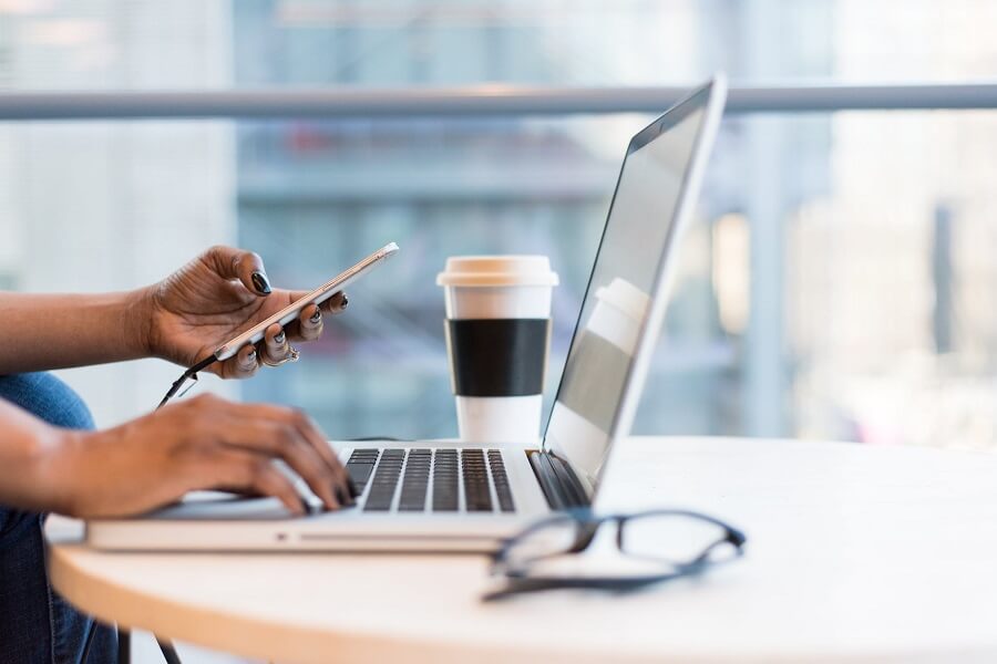 Someone working on a laptop with a coffee